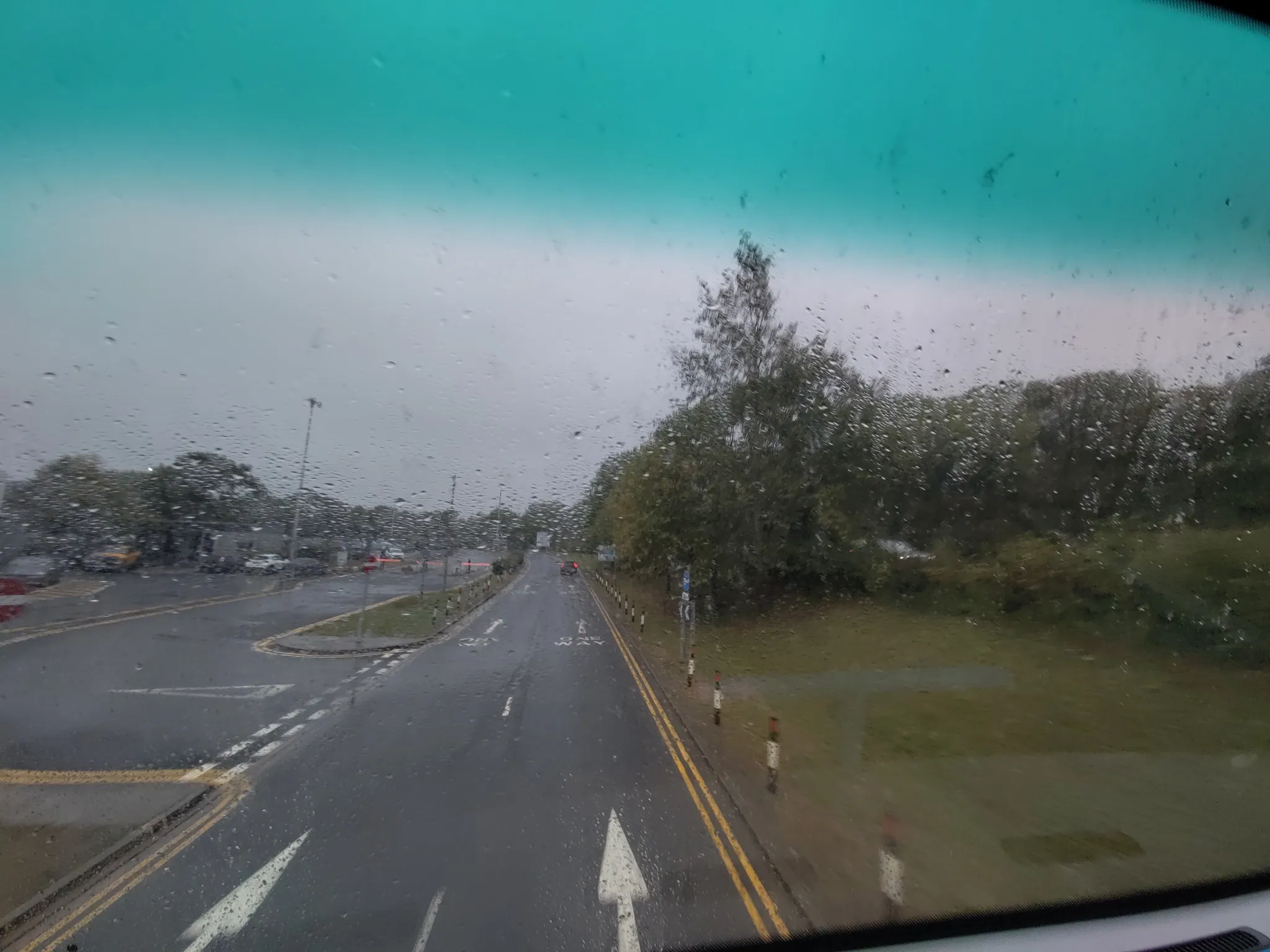 Blick aus der Frontscheibe eines Busses. Alles Nass und verregnet.