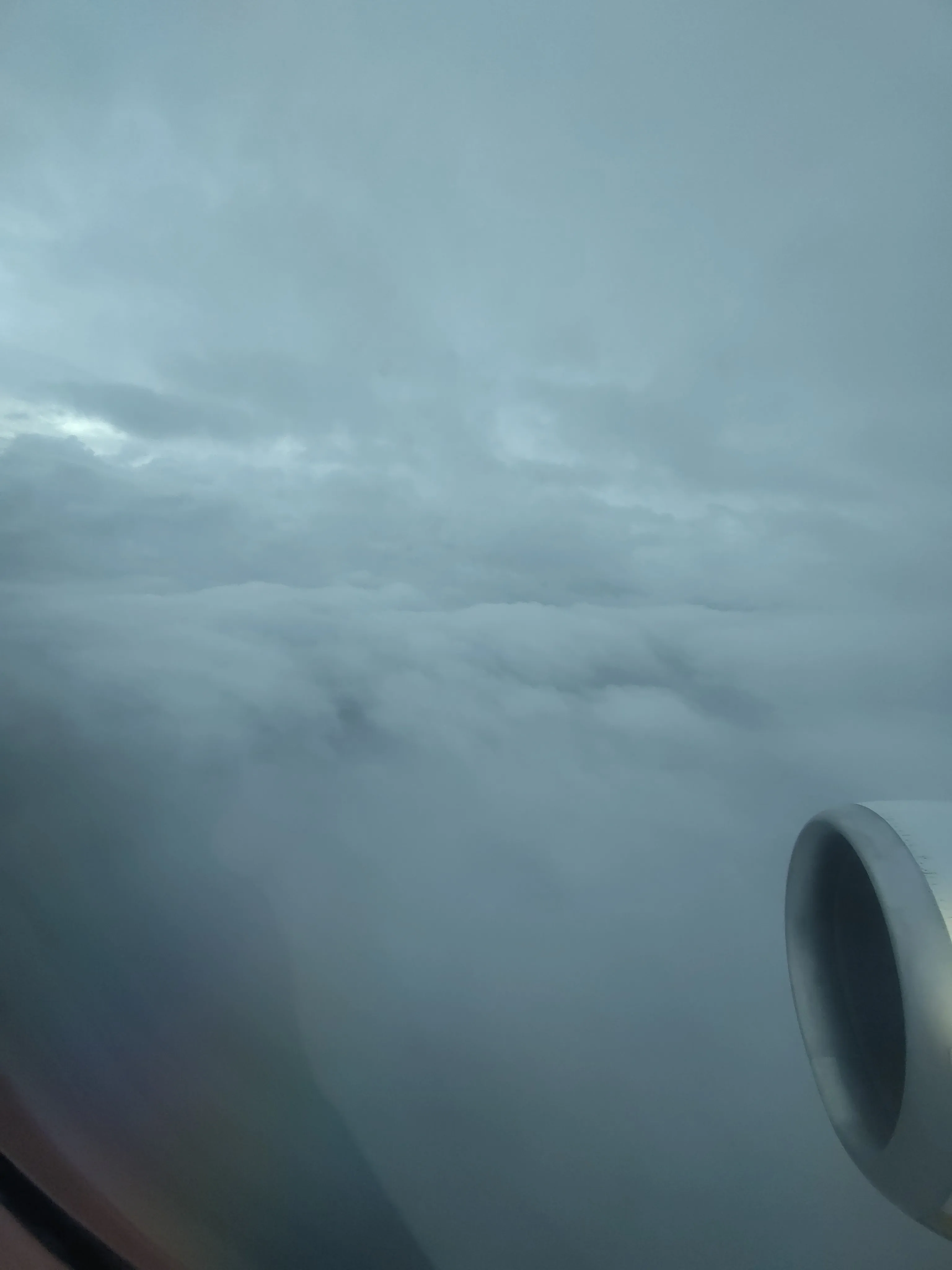 Blick aus dem Flugzeugfenster auf große Wolkenformationen.