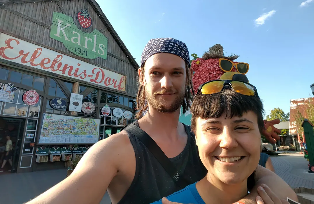 Chiara und Tim stehen vor dem Eingangsschild zum Karls Erlebnisdorf in Rövershagen.