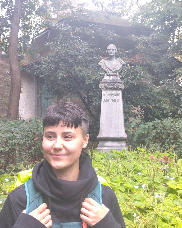 Chiara steht neben einem Denkmal für Königin Astrid.